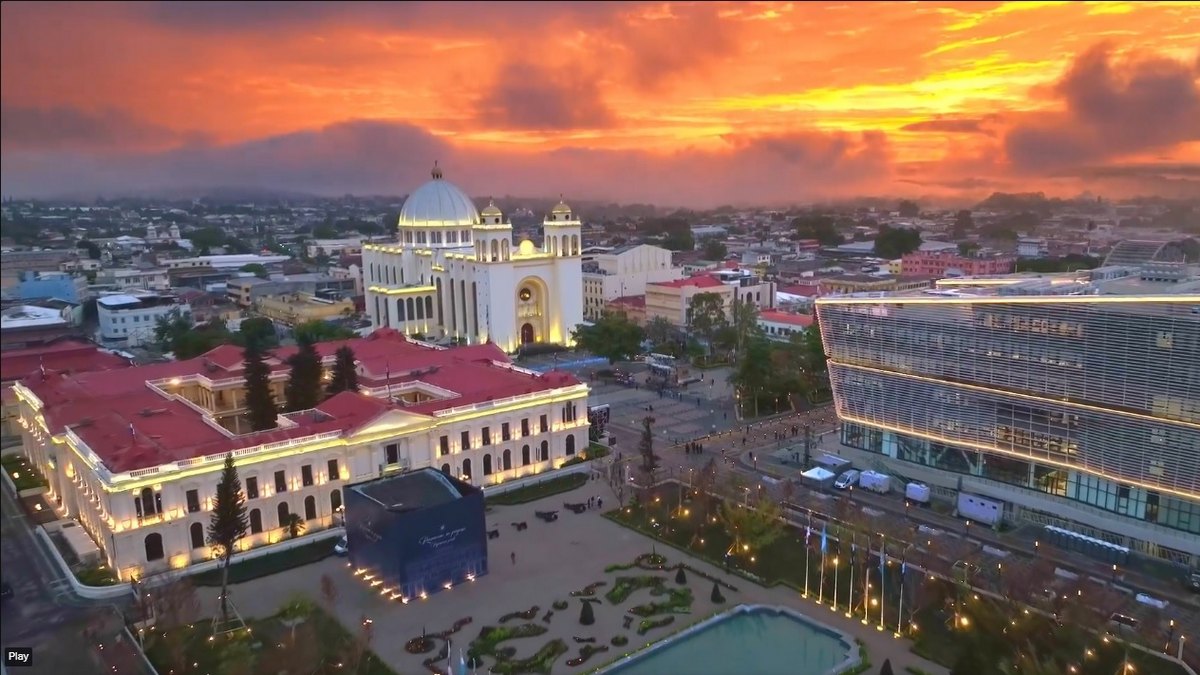 Screenshot z videa ukazující zrekonstruovaný Národní palác v San Salvadoru (nalevo). Za ním je vidět Metropolitní katedrála a napravo moderní budova Národní knihovny. (screenshot z X)